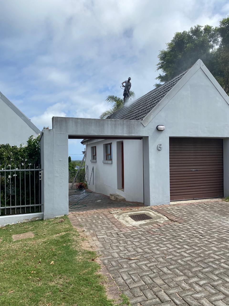 Pressure washing a roof.